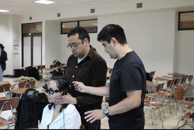 Docentes guiando una evaluación vestibular con gafas de videonistagmografía
